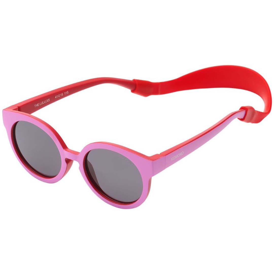 Komono kinderzonnebril met roze montuur, rode pootjes en een rood brillenkoord.