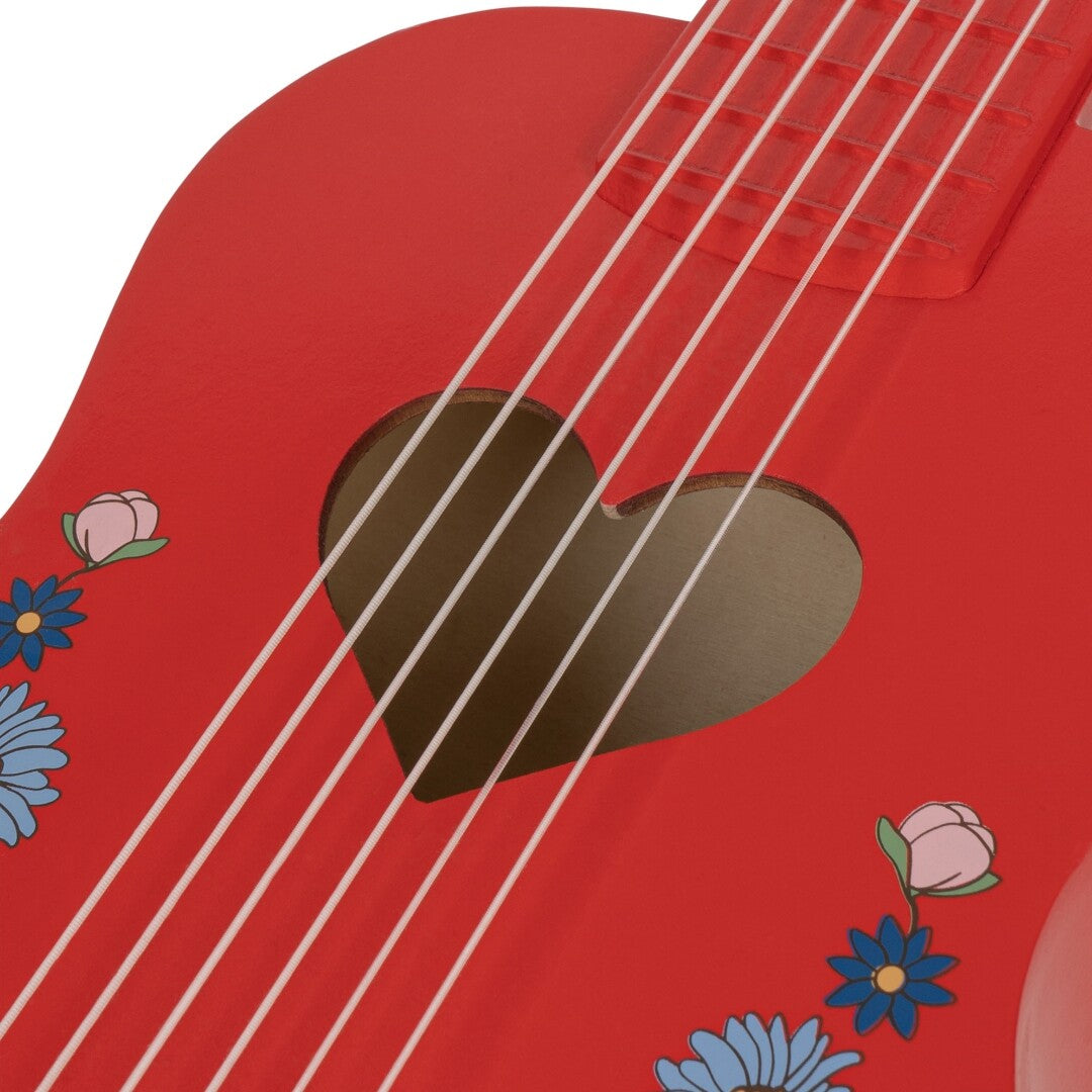 Detail van de rode speelgoedgitaar met hartvormig klankgat en bloemenpatroon.