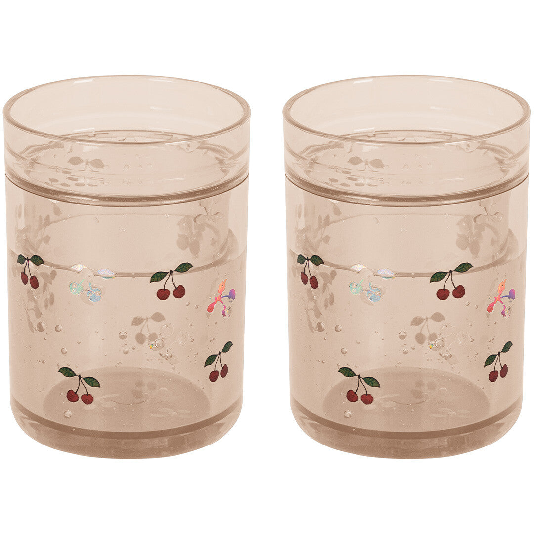 Twee Konges Sløjd kinderbekers van beige plastic met glitter en kersenpatroon.