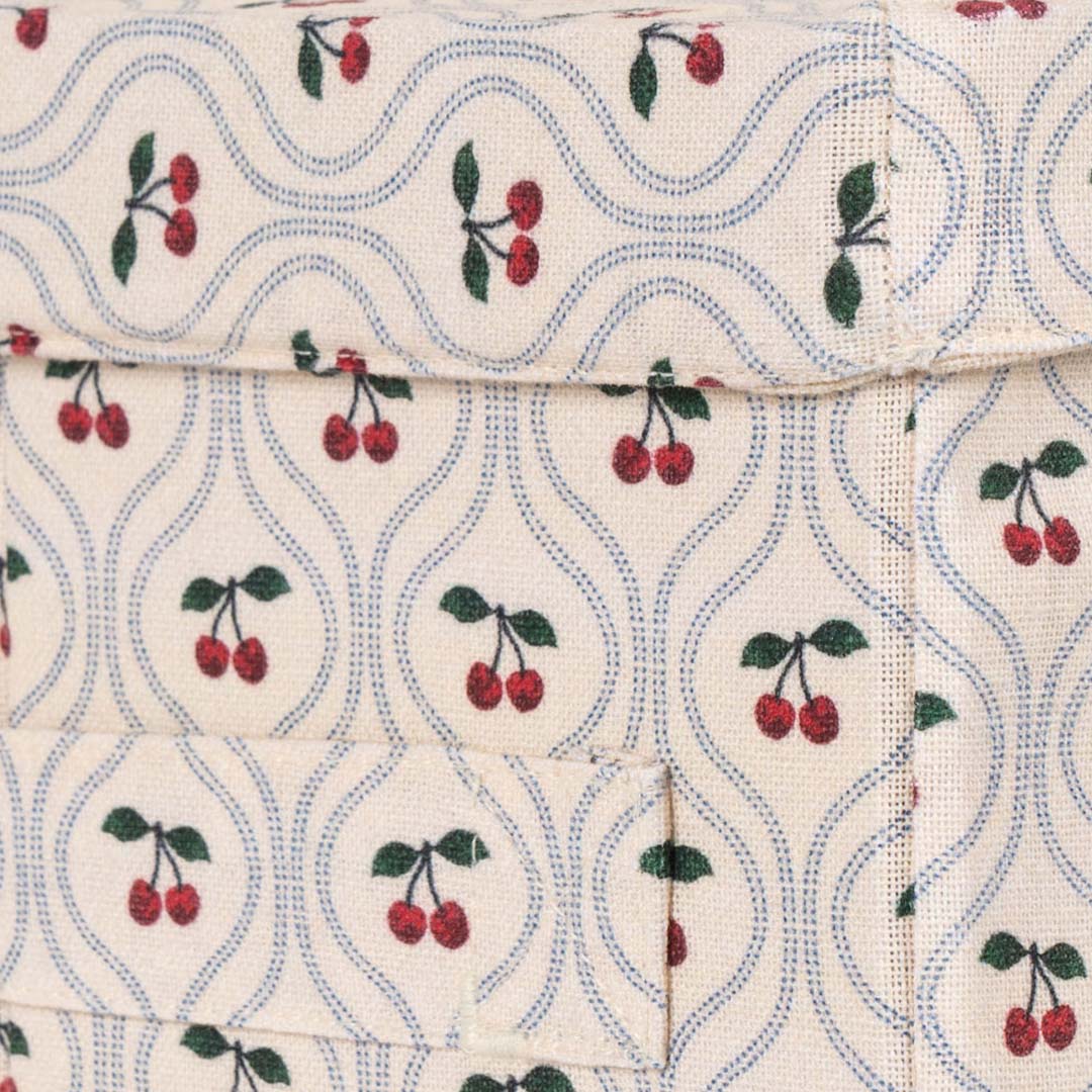 Detail van de Konges Sløjd opbergdoos met beige stof, blauwe lijnen en kersenmotief.