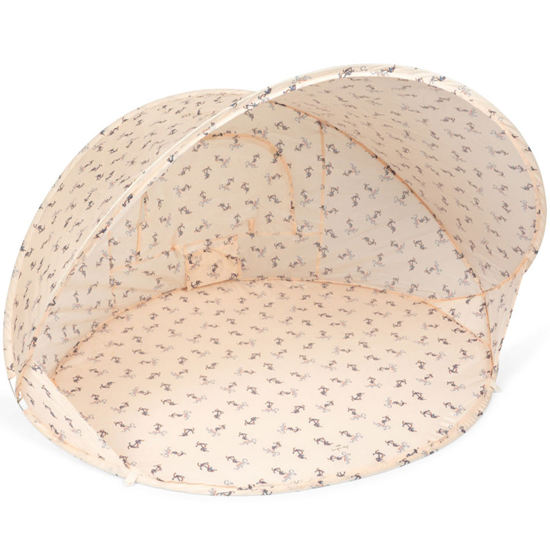 Konges Sløjd beige pop-up strandtent met nautisch patroon, open en van binnenuit zichtbaar.