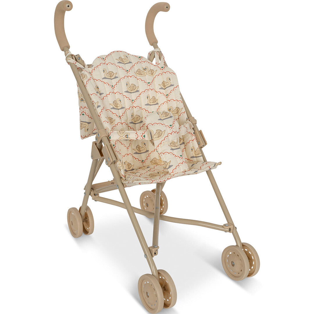 Konges Sløjd poppenbuggy in beige met zwanenpatroon, schuin van voren gefotografeerd.