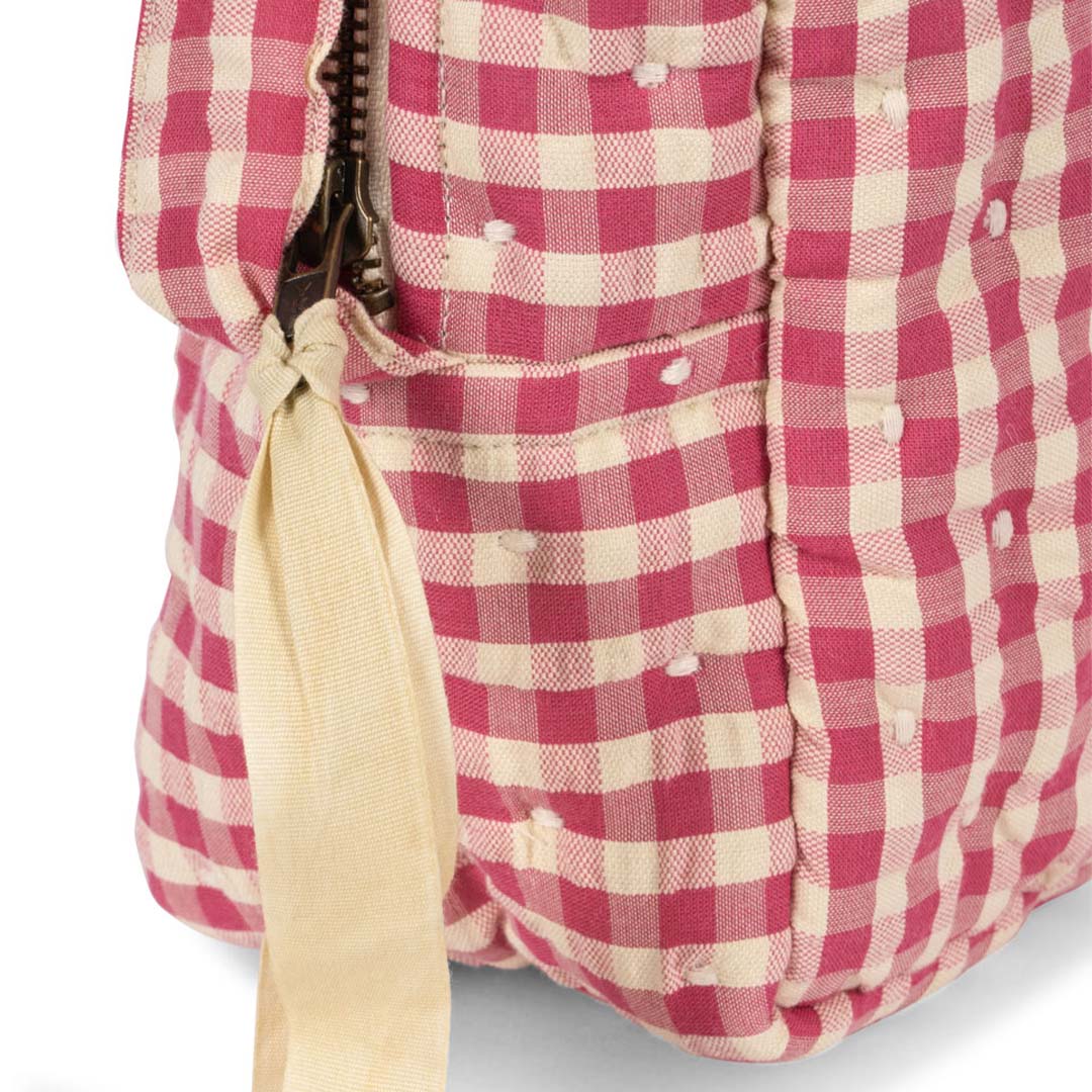 Detail van de Konges Sløjd poppenluiertas met roze-wit ruitpatroon en een rits.
