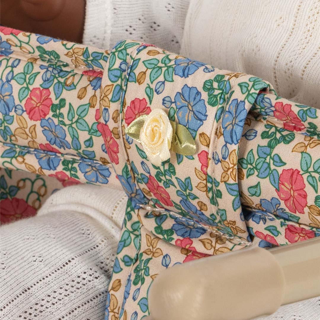 Detail van de gebloemde stof van de poppentafelstoel met een kleine gele roos.