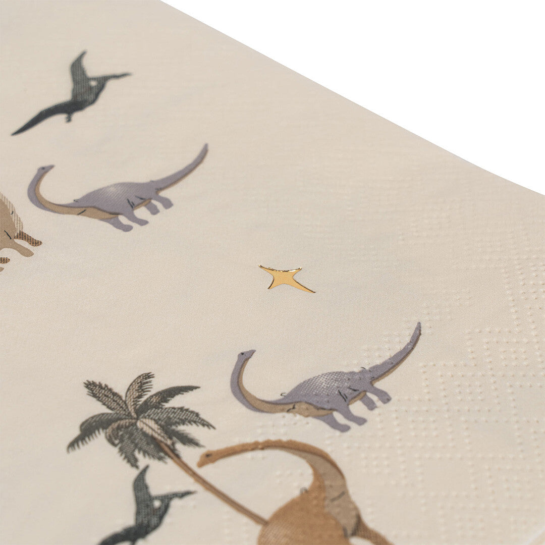 Detail van een Konges Sløjd papieren servet met een dinosaurus-, palmboom- en sterrenpatroon.