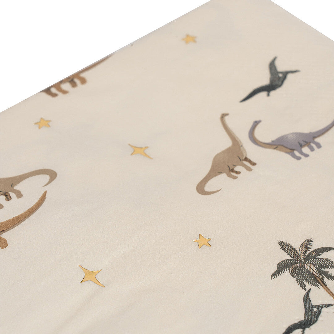 Detail van een Konges Sløjd papieren servet met een dinosaurus-, palmboom- en sterrenpatroon.