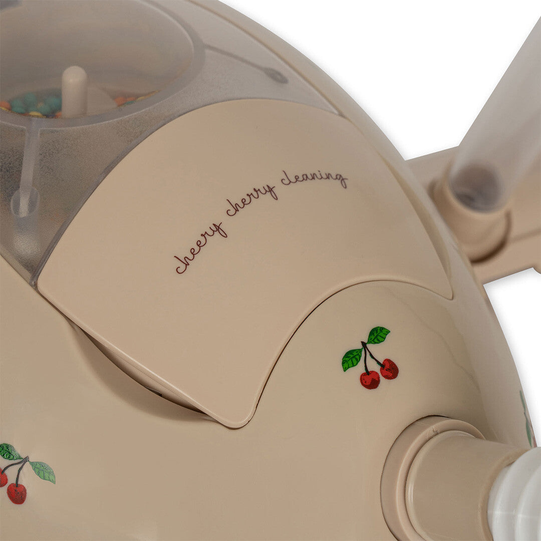 Detail van de beige speelgoed stofzuiger met de tekst 'cherry cherry cleaning' en kersjes.