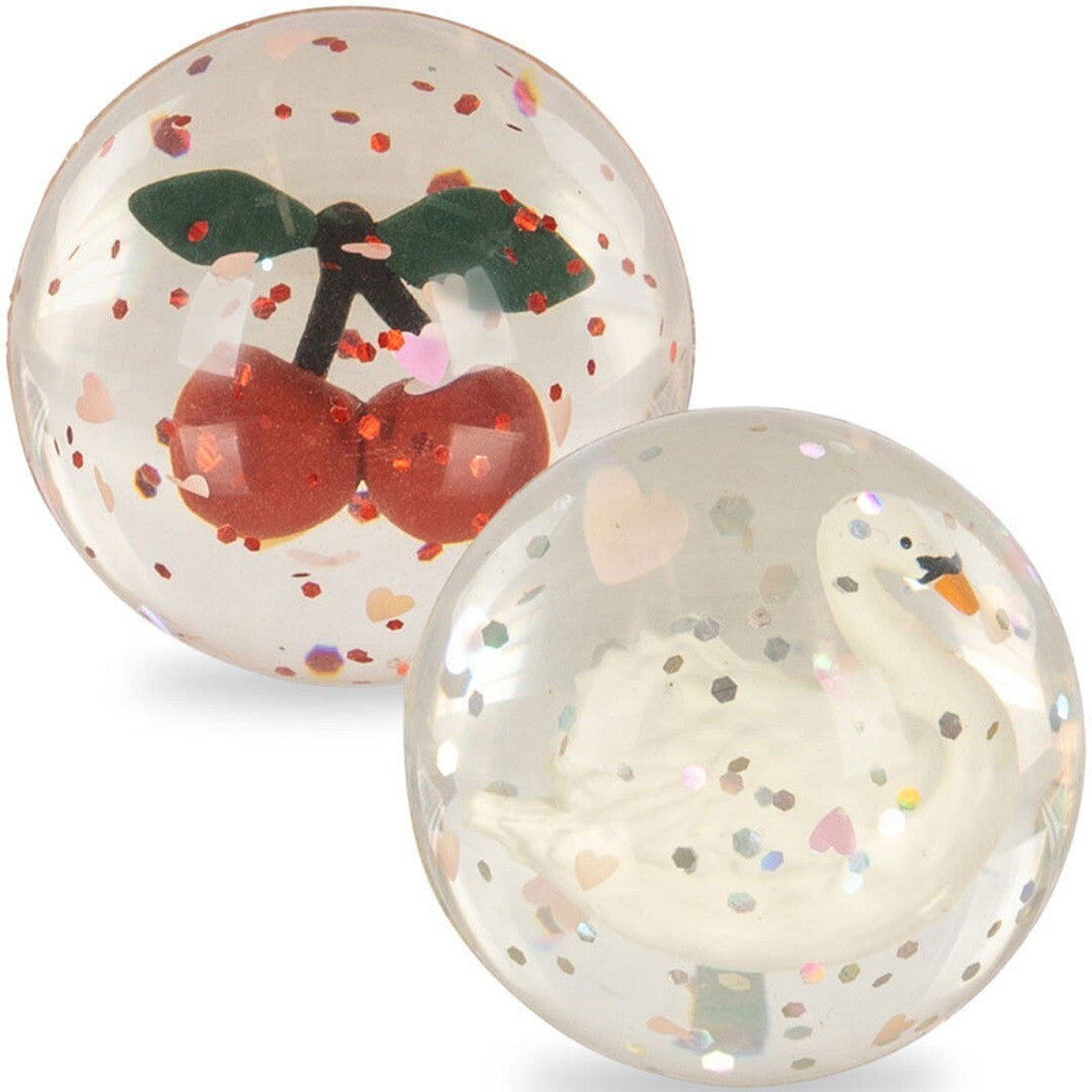 Twee Konges Sløjd stuiterballen, één met kersen en één met een zwaan, gevuld met glitter.