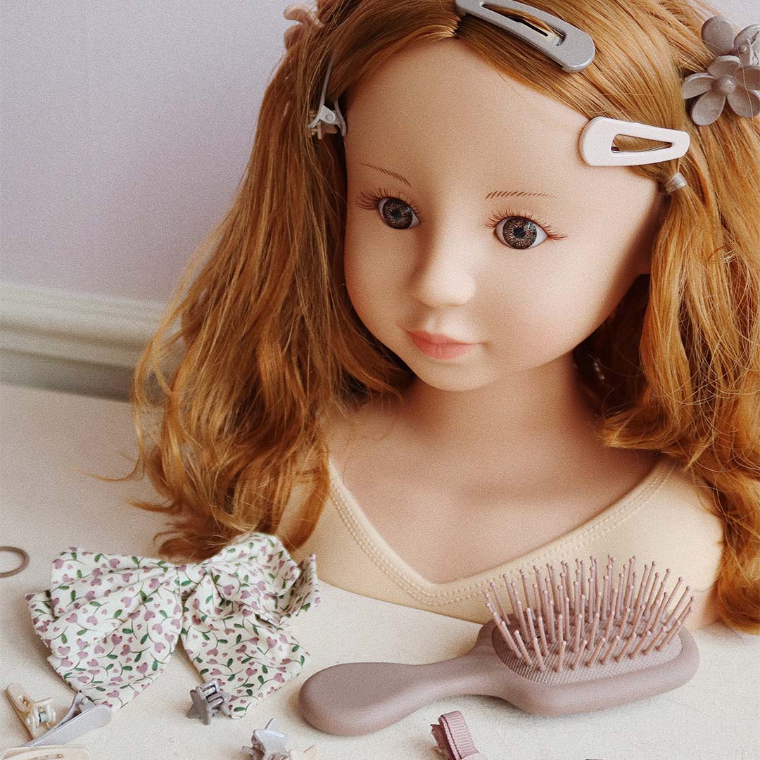 De Konges Sløjd styling pop met haarclips, een borstel en een gebloemde strik.
