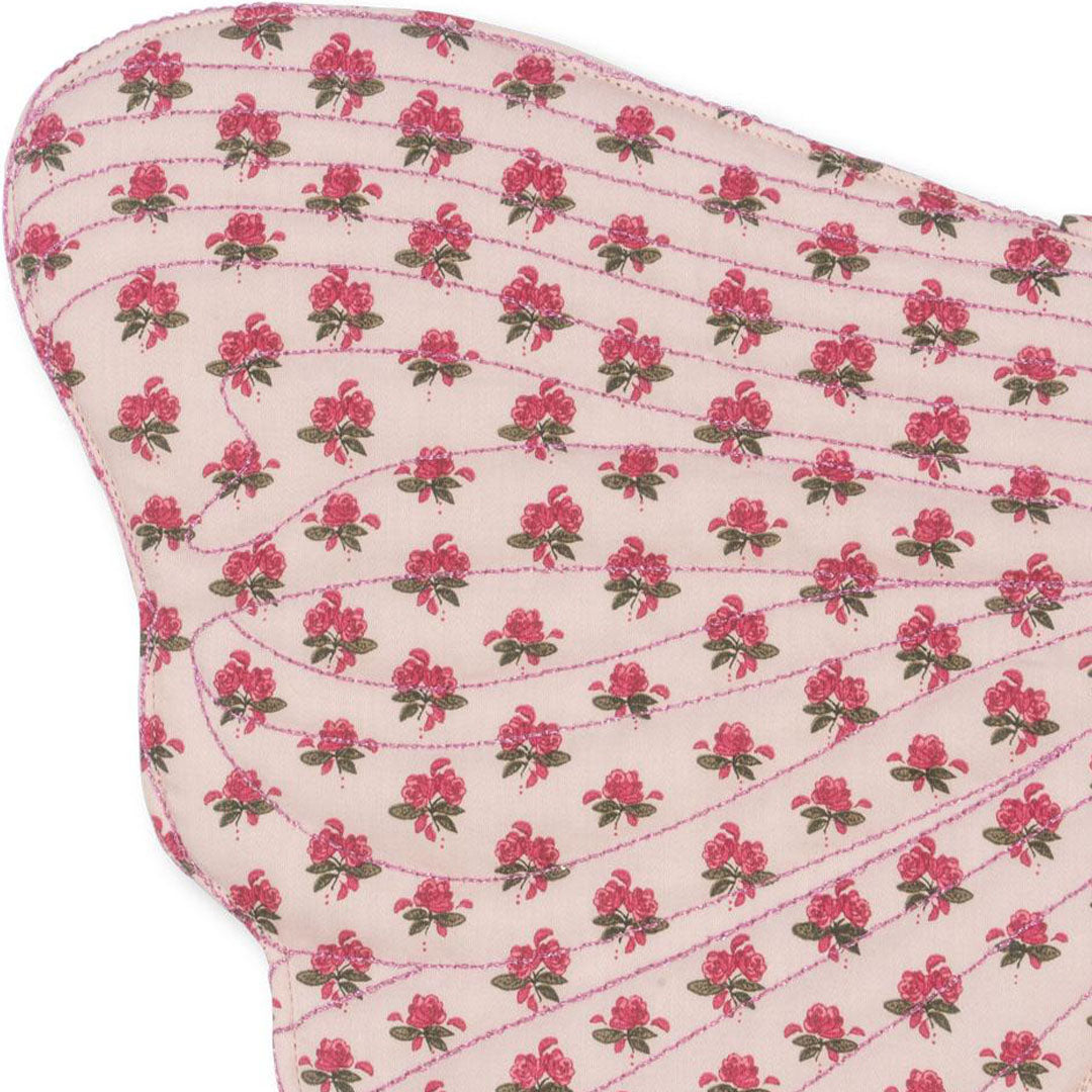 Detail van het roze gebloemde patroon op de vlindervleugels van de kostuumset.