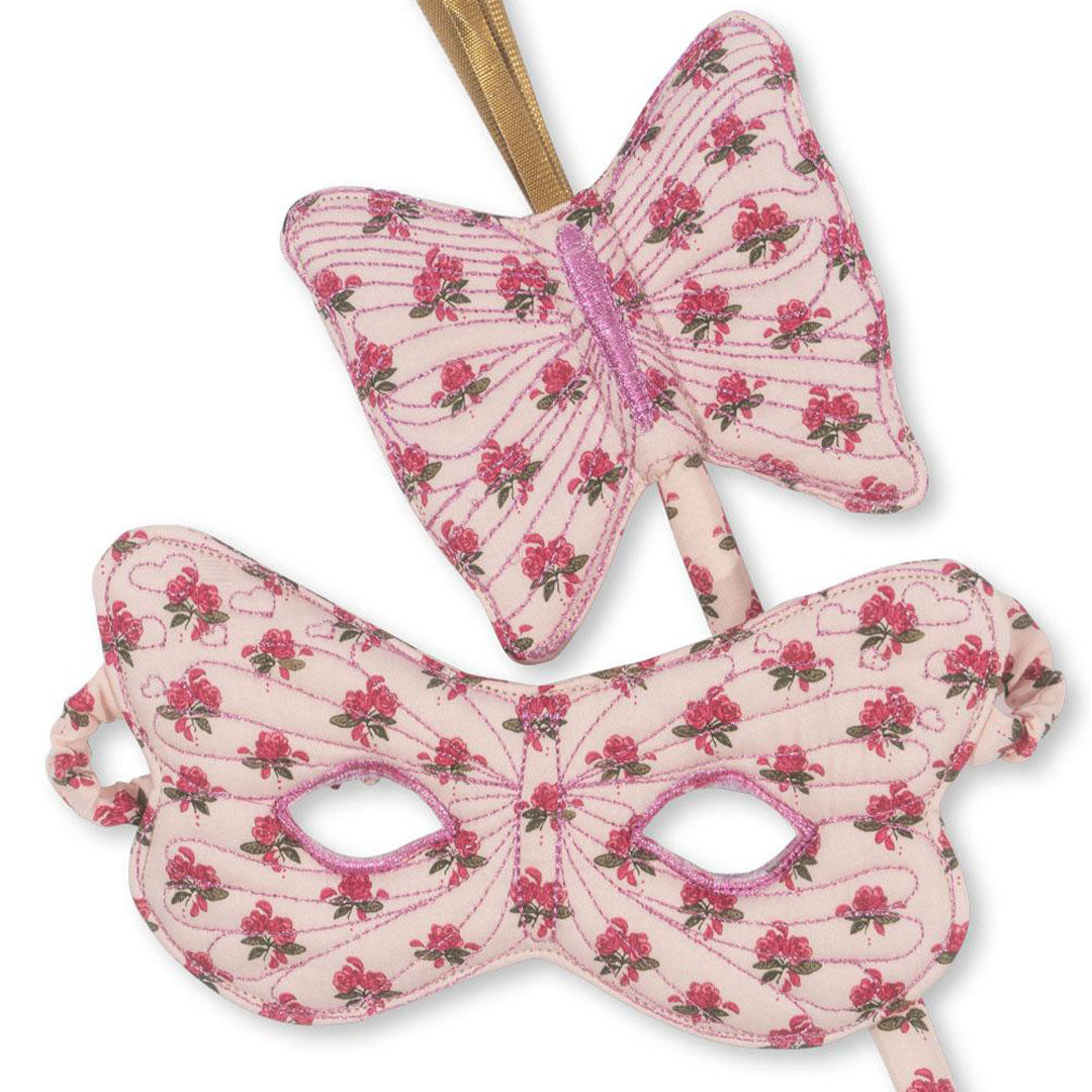 Detail van het vlindermasker en de toverstaf met roze gebloemd patroon.