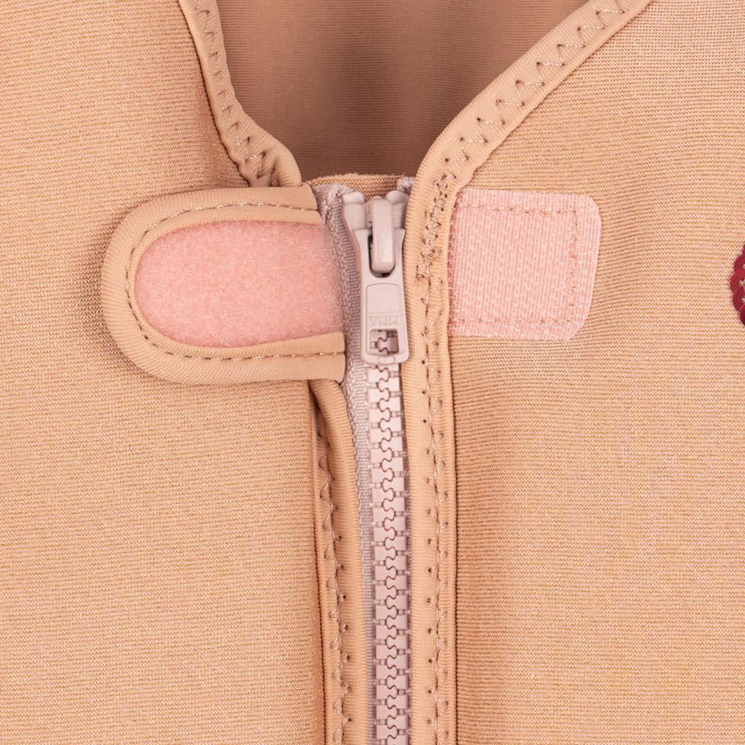 Detail van de rits en klittenbandsluiting van het beige kinderzwemvest.