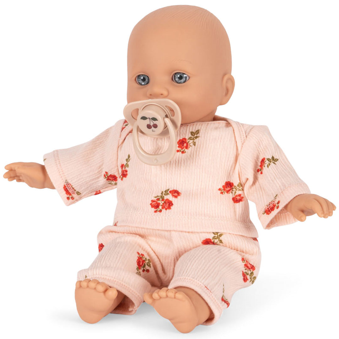 Konges Sløjd babypop Elisa zittend met roze gebloemd pakje en speen met kersenmotief.