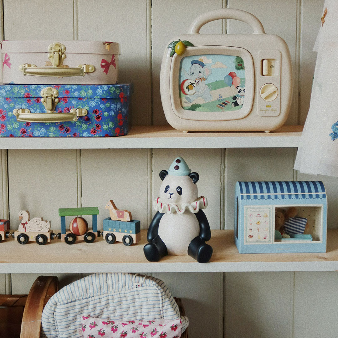 De twee Konges Sløjd kinderkoffers staan op een houten plank in een kinderkamer, omringd door speelgoed.