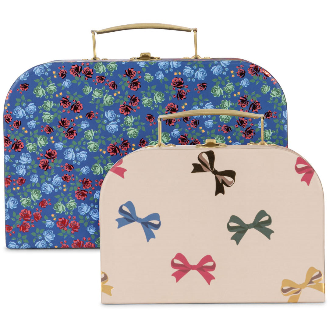 Twee Konges Sløjd kinderkoffers van voren gezien, een blauwe met bloemen en een kleinere beige met strikjes.