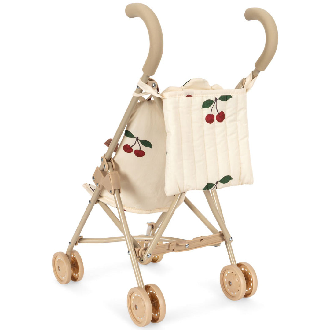 Achterkant van de Konges Sløjd poppenbuggy met beige frame en kersenprint stof.