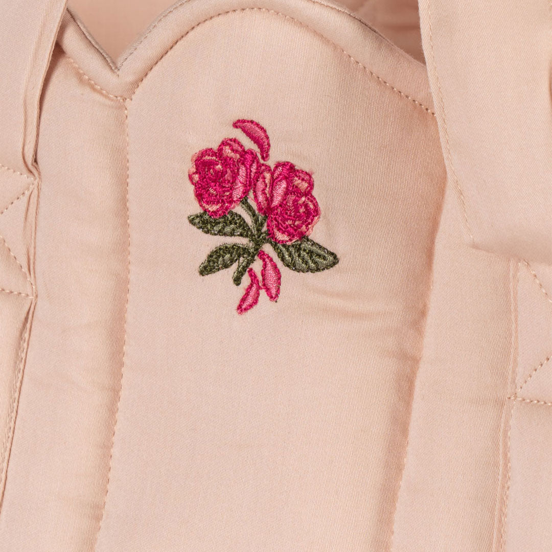 Detail van de roze poppenreiswieg met geborduurde rozen.