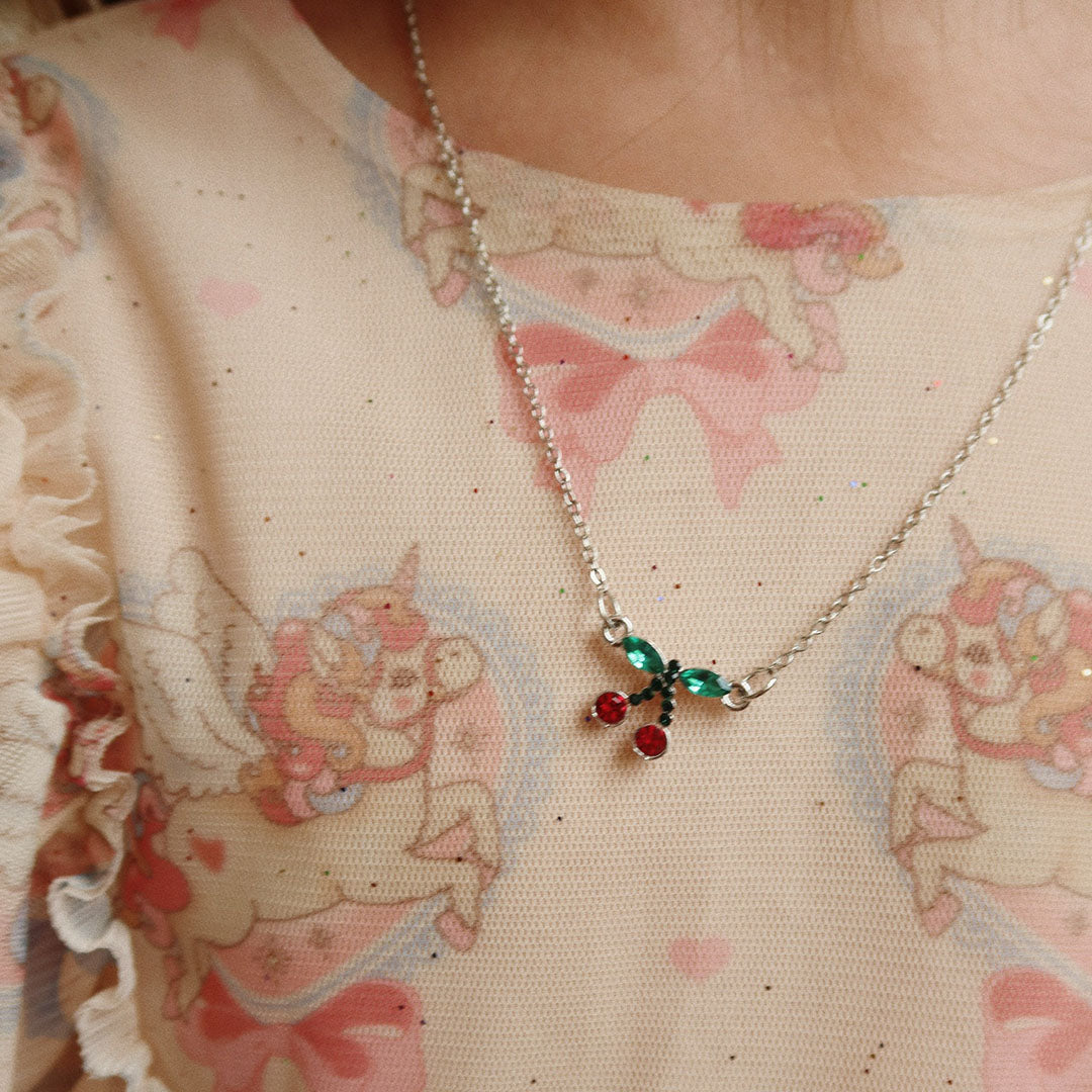 Detail van de Konges Sløjd kinder ketting met een kersen hanger.