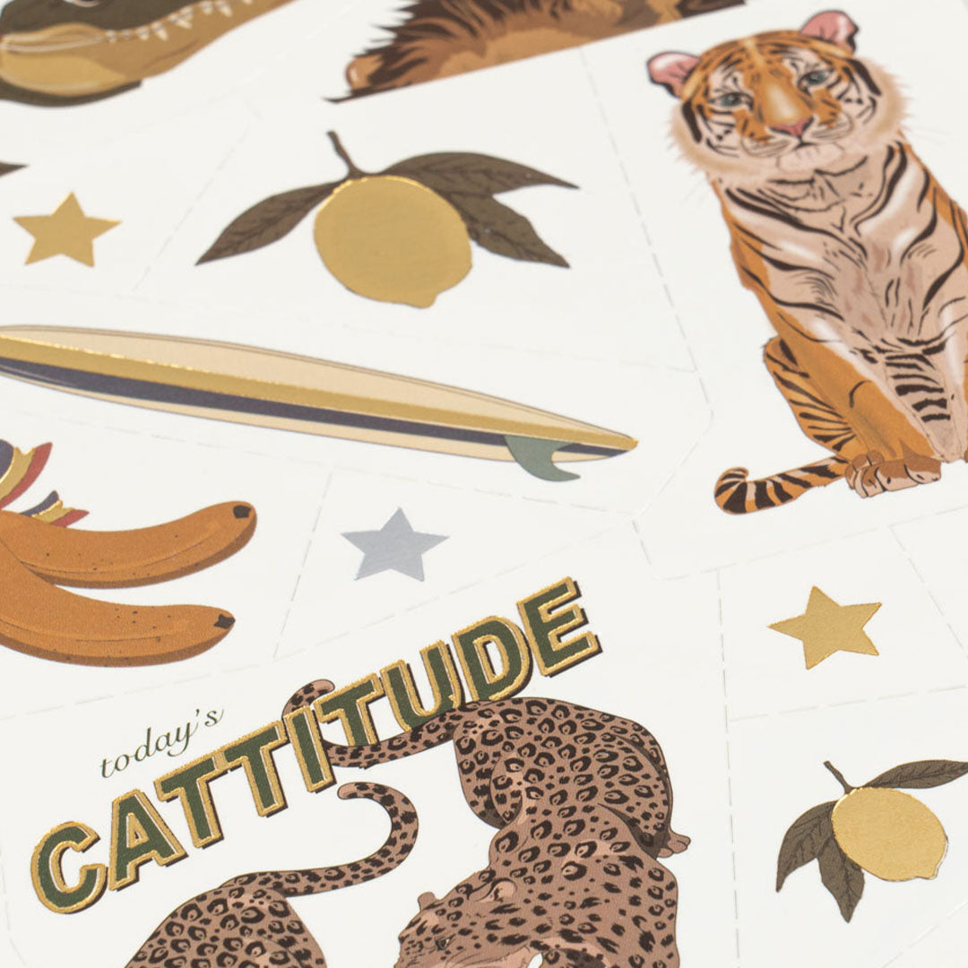 Detail van tijdelijke tatoeages voor kinderen met een zittende tijger, surfboard, bananen en de tekst 'today's CATTITUDE'.