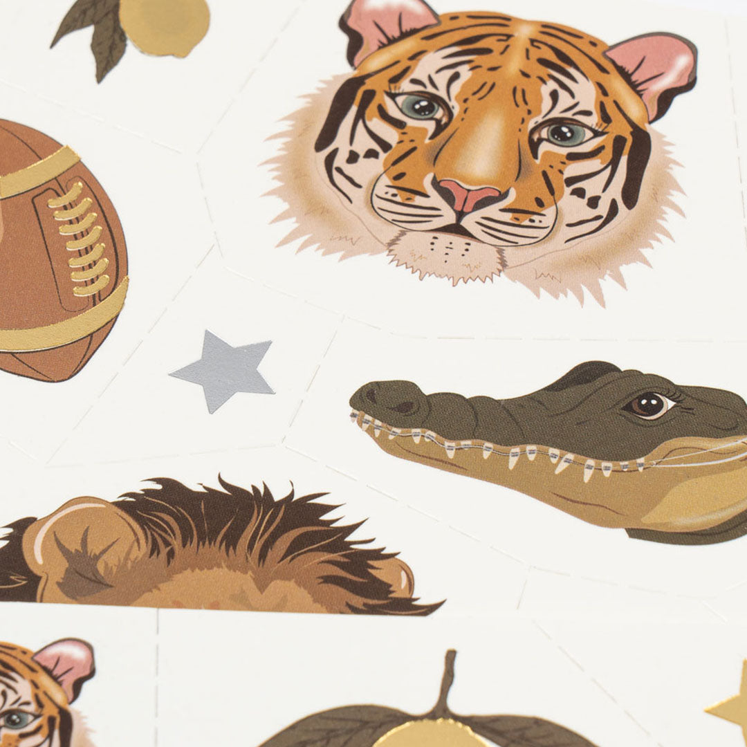 Detail van tijdelijke tatoeages voor kinderen met een tijgerkop, rugbybal, krokodillenkop en sterren.