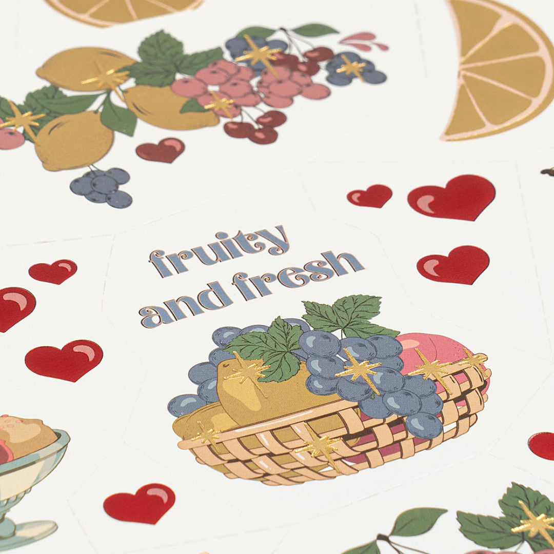 Detail van een vel tijdelijke tatoeages voor kinderen met een fruitmand, harten en de tekst 'fruity and fresh'.