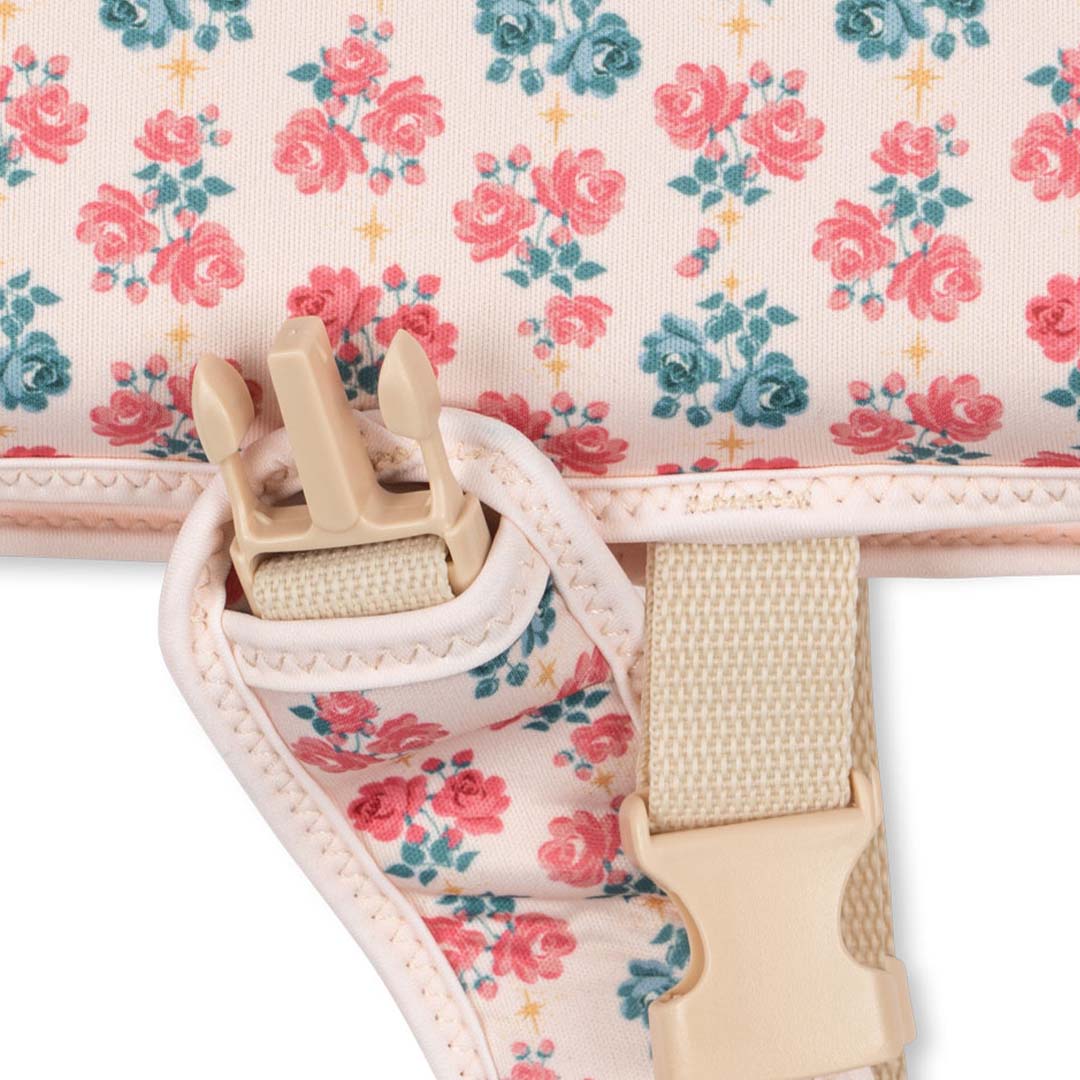 Detail van een beige gesp en bandje op het gebloemde zwemvest.