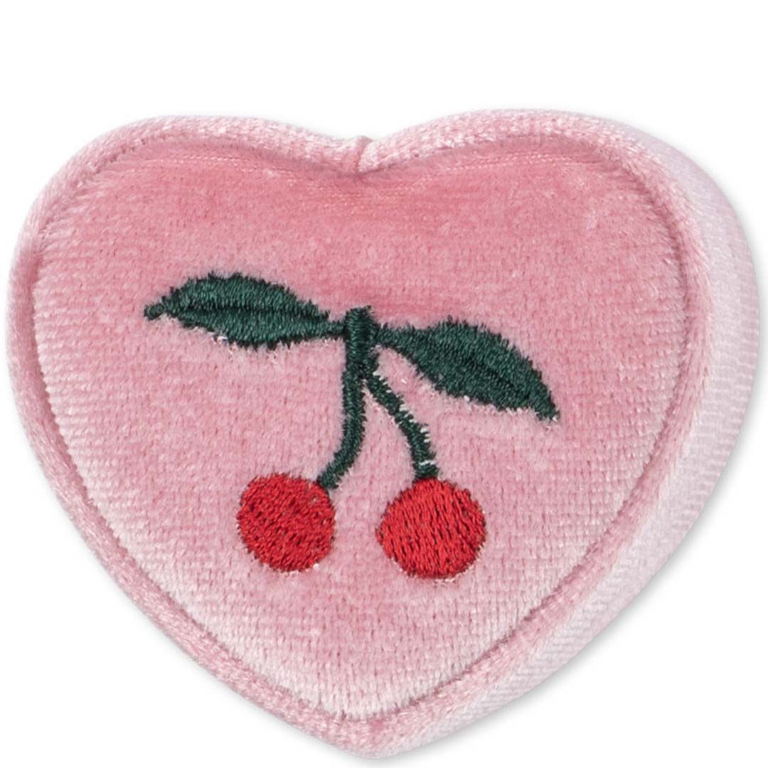 Detail van de roze fluwelen deksel van het doosje met geborduurde kersen.