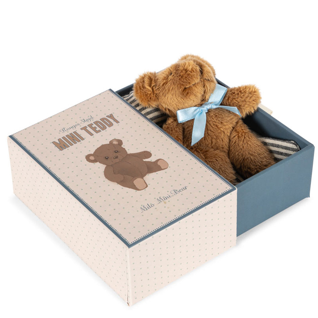 Konges Sløjd pluchen mini teddybeer in de open geschenkdoos, liggend op gestreepte stof.