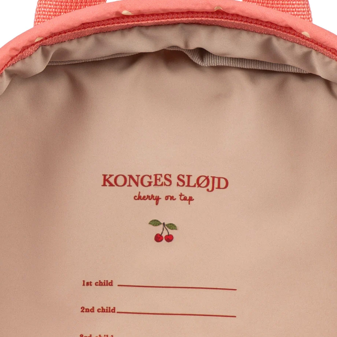 Binnenlabel van de Konges Sløjd peuterrugzak met merknaam en invulregels voor namen.