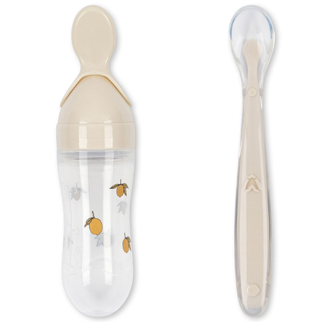 Konges Sløjd babyvoedingsset met beige knijpfles met citroenpatroon en een losse babylepel.