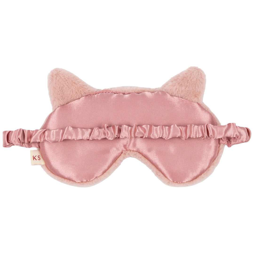 De achterkant van het roze katten slaapmasker, gemaakt van gladde roze stof met een elastische band.