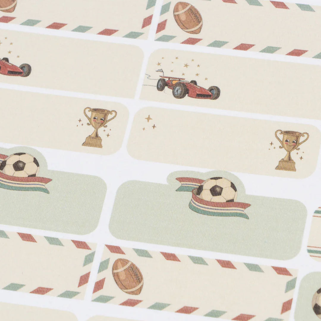 Detail van beige naamstickers met illustraties van raceauto's, trofeeën en sportballen.