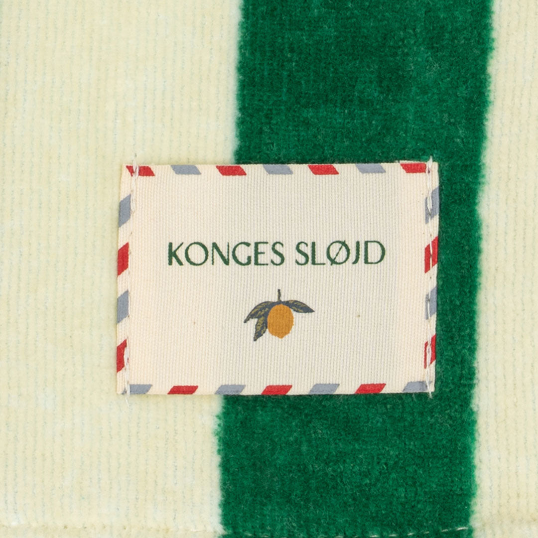 Detail van het Konges Sløjd merklabel op het gestreepte strandlaken.