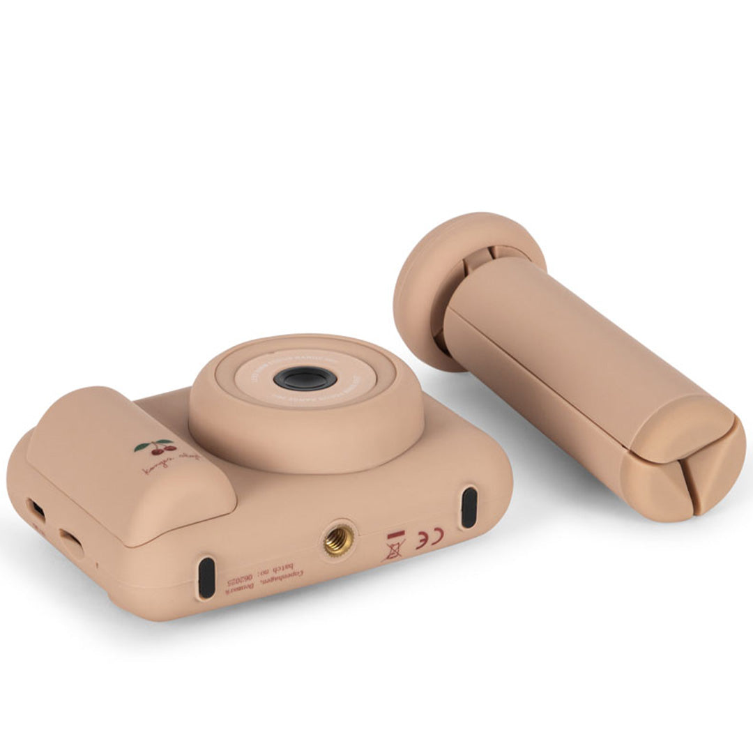 De achterkant van de Konges Sløjd kindercamera met kersjespatroon, naast het losse statief.