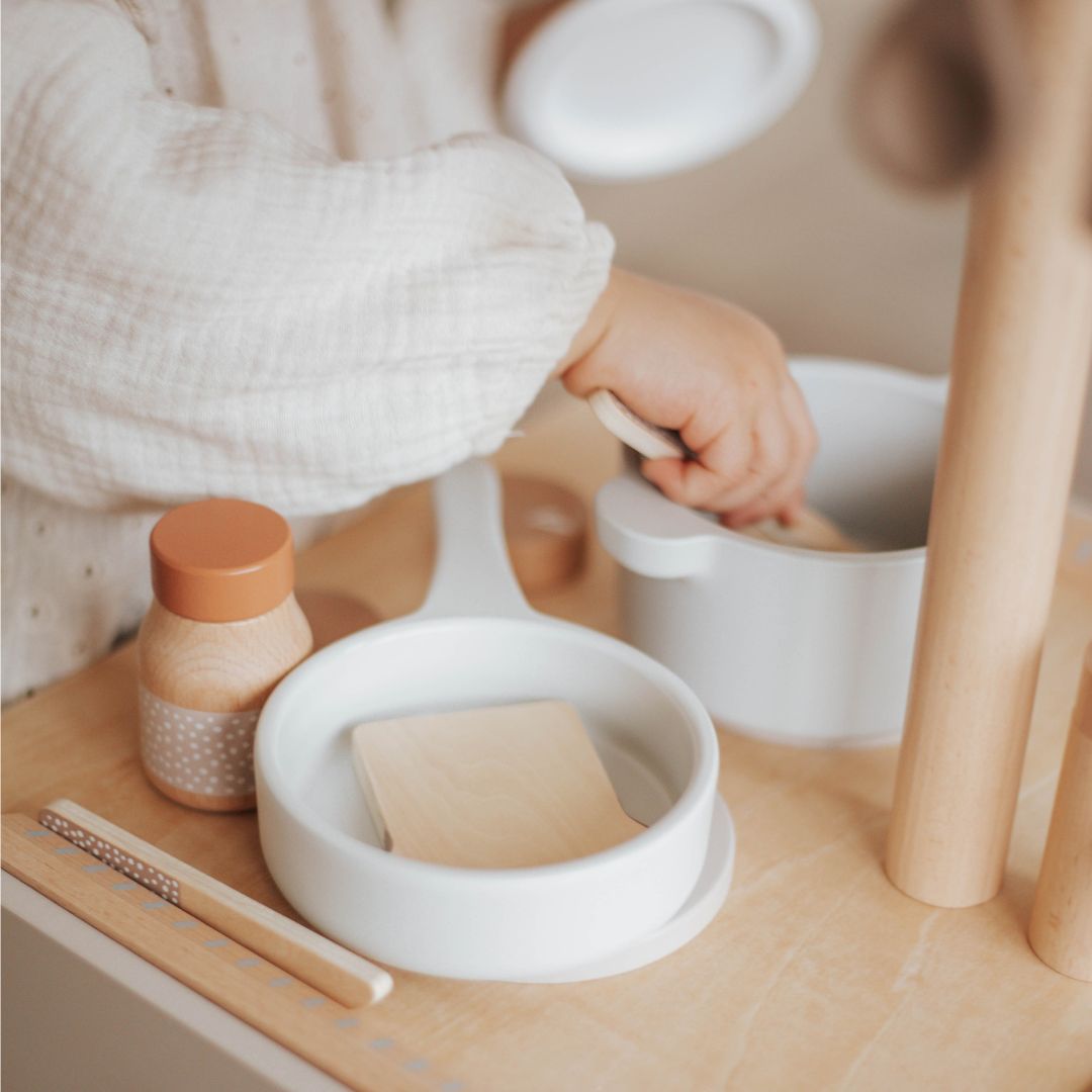 Detail van de kookplaat van de Label Label houten kinderkeuken met pan, pot en kruidenpotje.