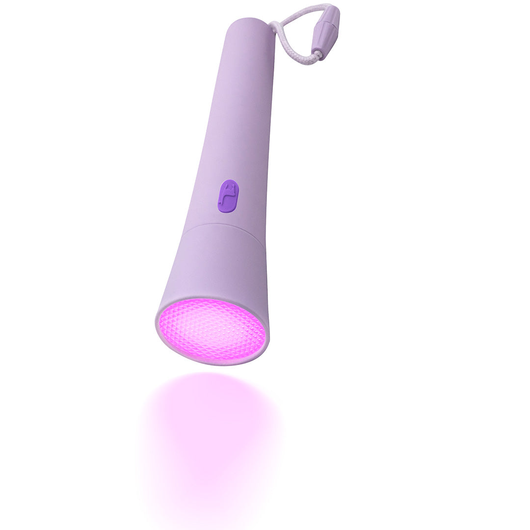 Lalarma paarse zaklamp met paars licht dat op een witte ondergrond schijnt, schuin gefotografeerd.