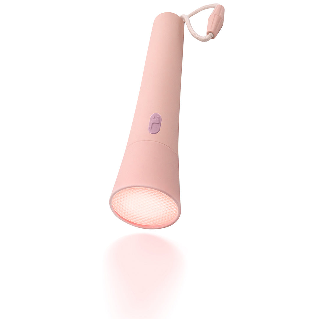 lalarma roze zaklamp met brandend licht en een zachte gloed eronder, schuin gefotografeerd.