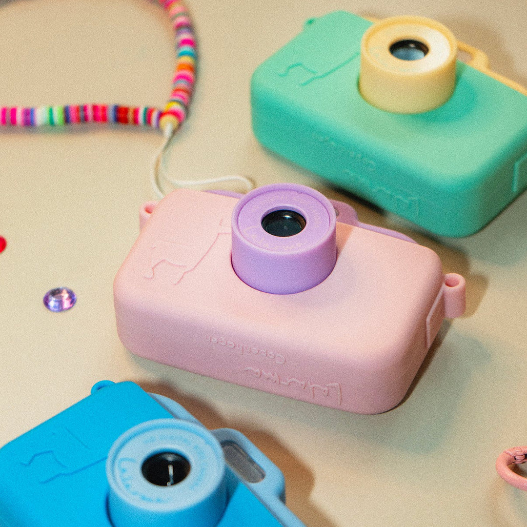 Drie lalarma copenhagen kindercamera's in roze, turquoise en groen met kleurrijke kralen polsbanden.