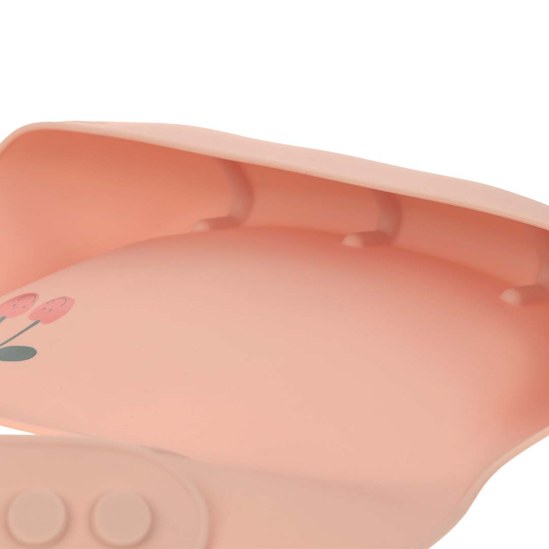 Detail van de binnenkant van het lässig roze siliconen slabbetje met kersendesign en opvangbakje.