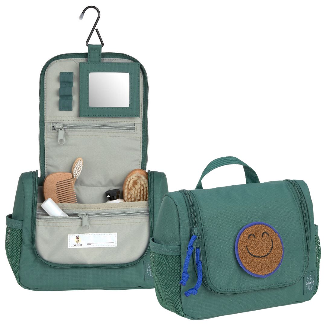 Lässig donkergroene toilettas met smiley-patch, openhangend met inhoud en gesloten naast elkaar.