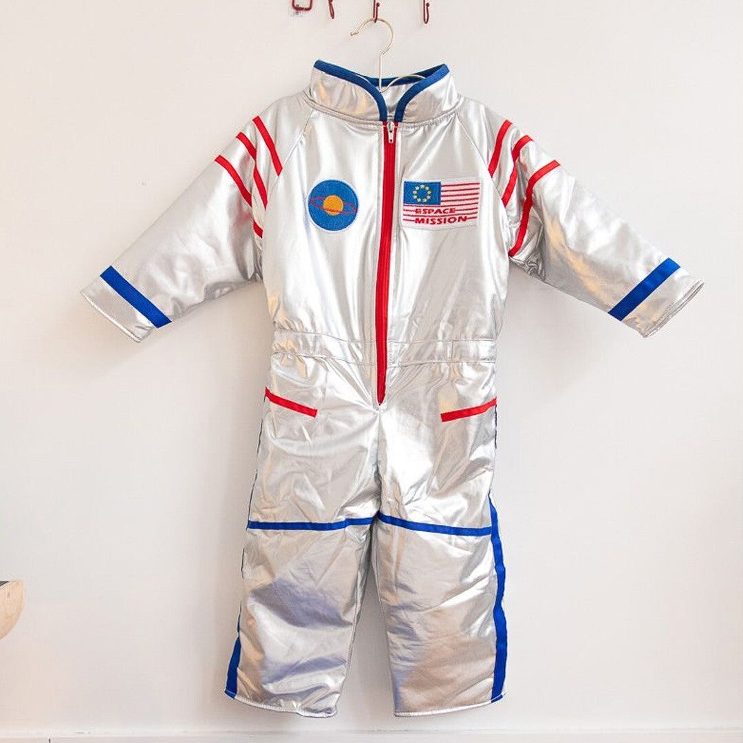 Le petit souk zilveren astronautenpak hangend aan een witte muur.