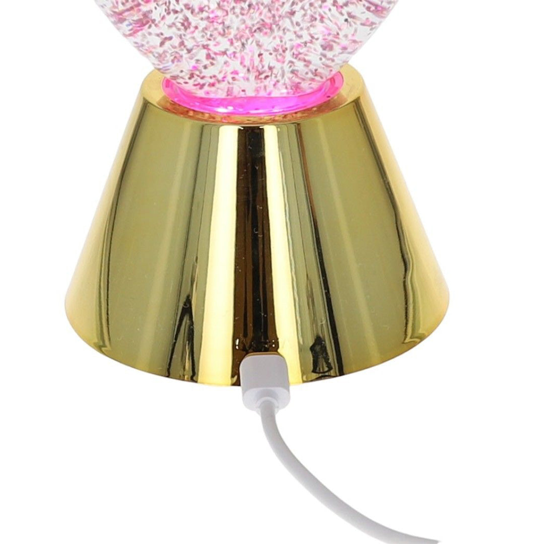Detail van de gouden voet van de glitterlamp met aangesloten witte USB-kabel.