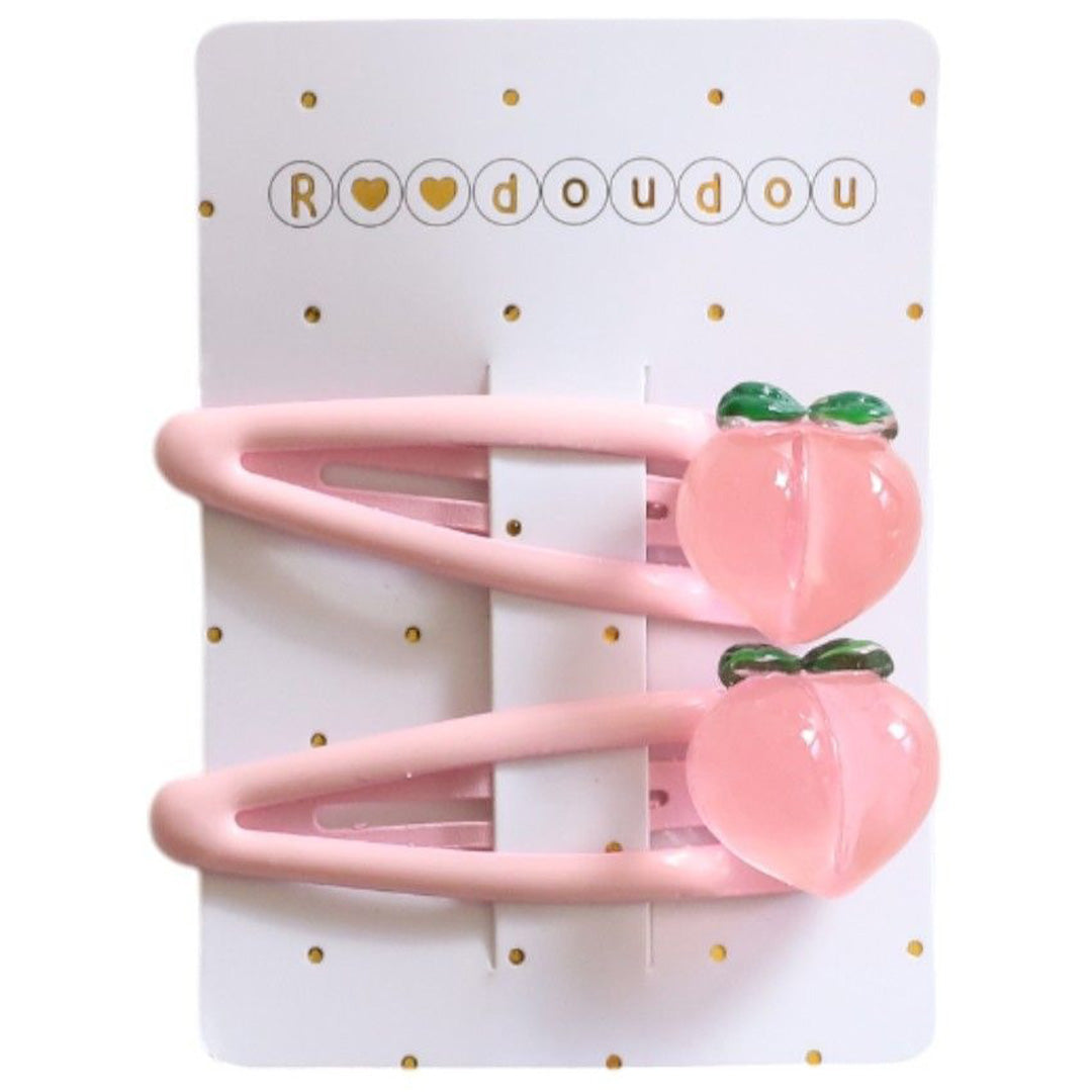 Verpakking van twee roze le petit souk haarspeldjes voor kinderen met een perzikfiguur.