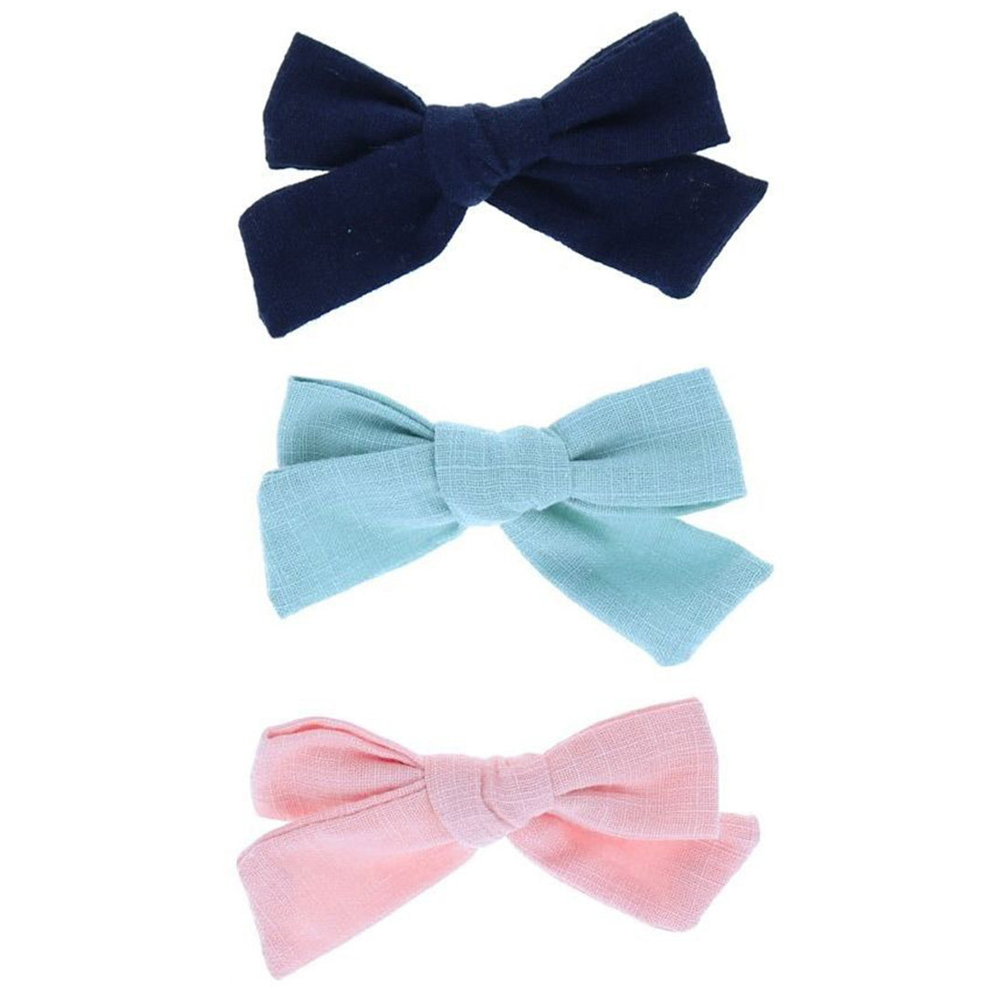 Drie le petit souk stoffen haarspeldjes in de vorm van strikjes in donkerblauw, lichtblauw en roze.