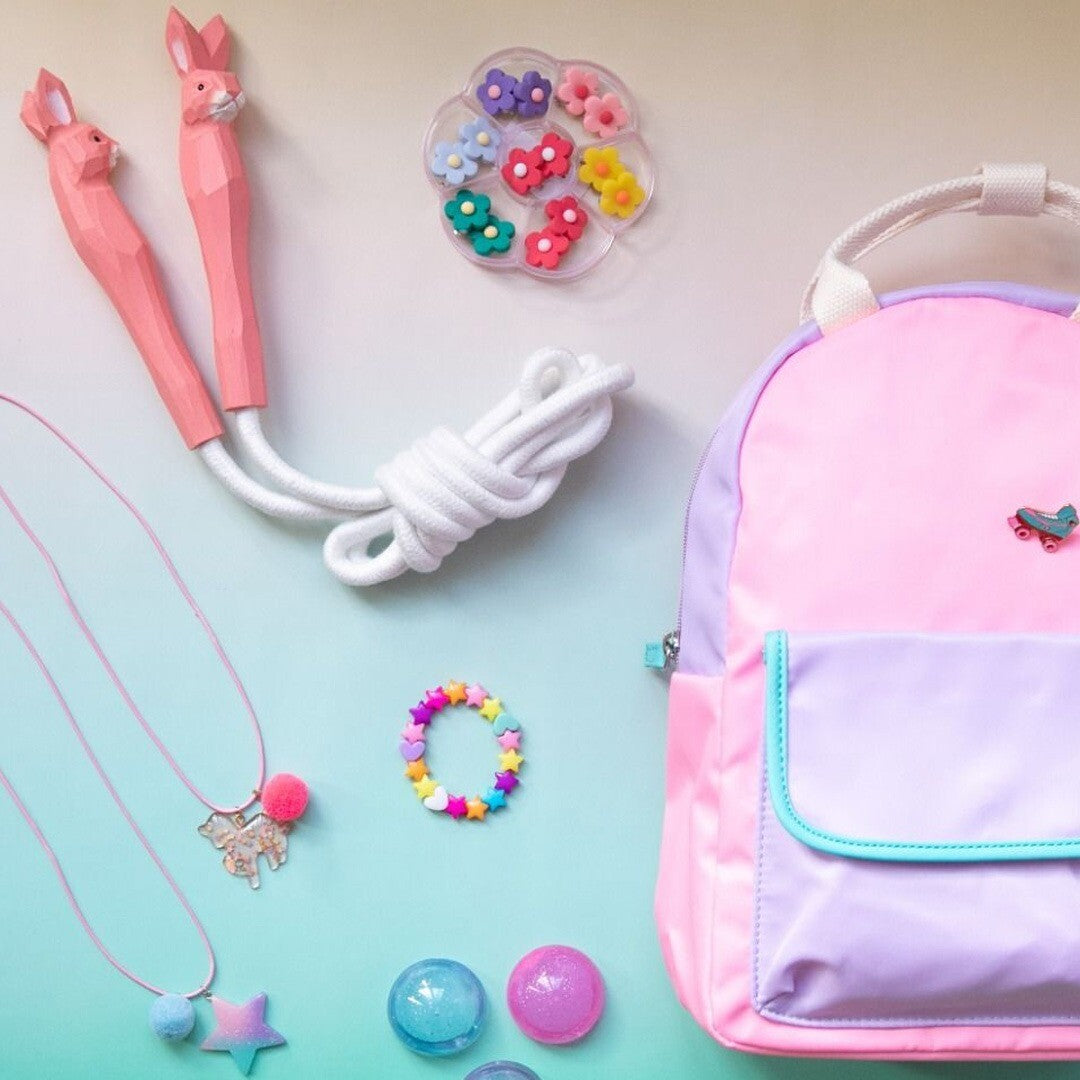 Een overzichtsfoto van diverse le petit souk kinderspeelgoed en accessoires, waaronder een rugzak, springtouw, kettingen en de bloem oorbellen set.
