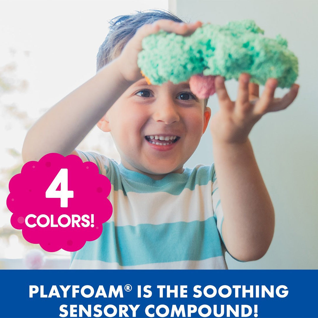 Een lachende jongen houdt een groen Playfoam sensorisch speelgoed vast.