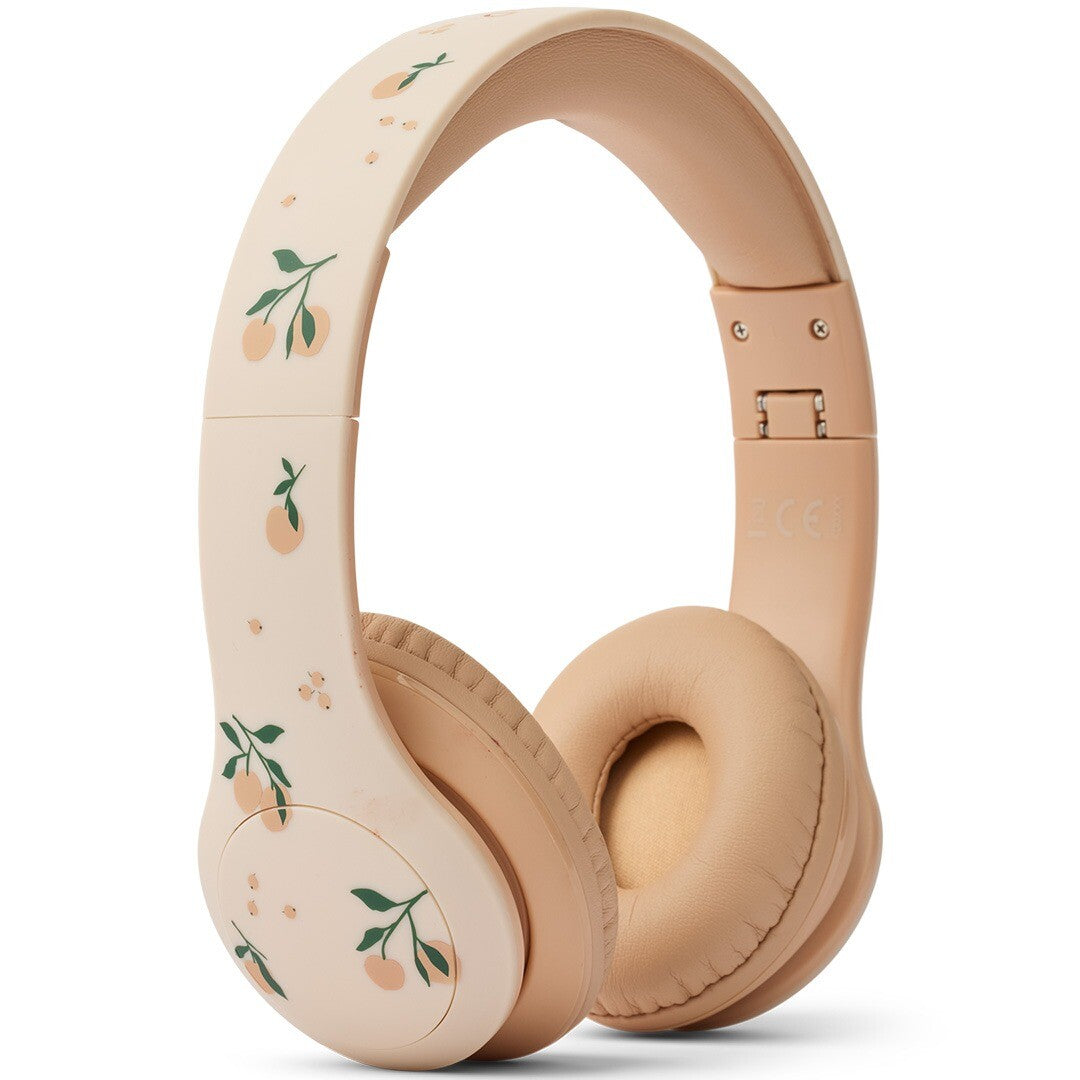 Liewood draadloze kinderkoptelefoon in beige met perzikjespatroon, schuin van voren gefotografeerd.