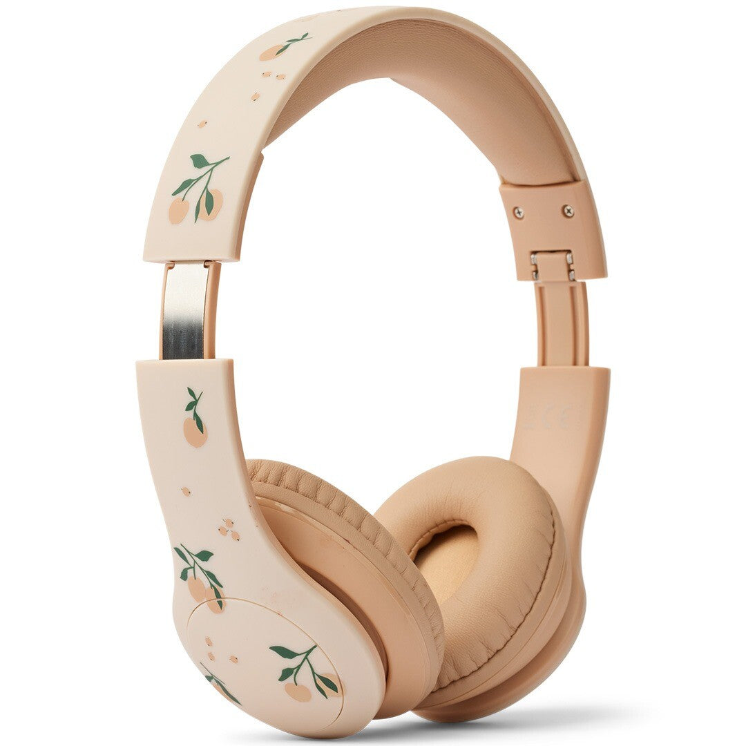 Liewood draadloze kinderkoptelefoon in beige met perzikjespatroon, recht van voren gefotografeerd.