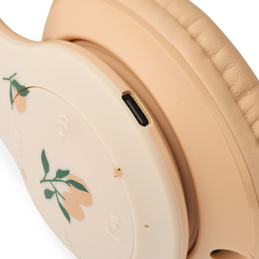 Detail van de zijkant van de Liewood kinderkoptelefoon met de USB type-C oplaadpoort en bedieningsknoppen.
