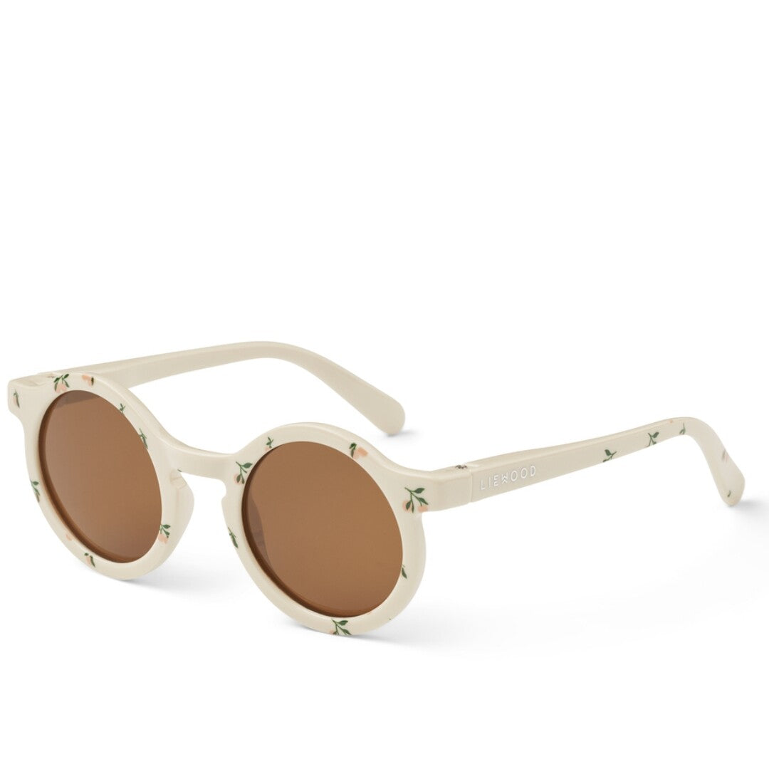 Liewood kinderzonnebril Darla in beige met gebloemd patroon en bruine glazen, schuin gefotografeerd.
